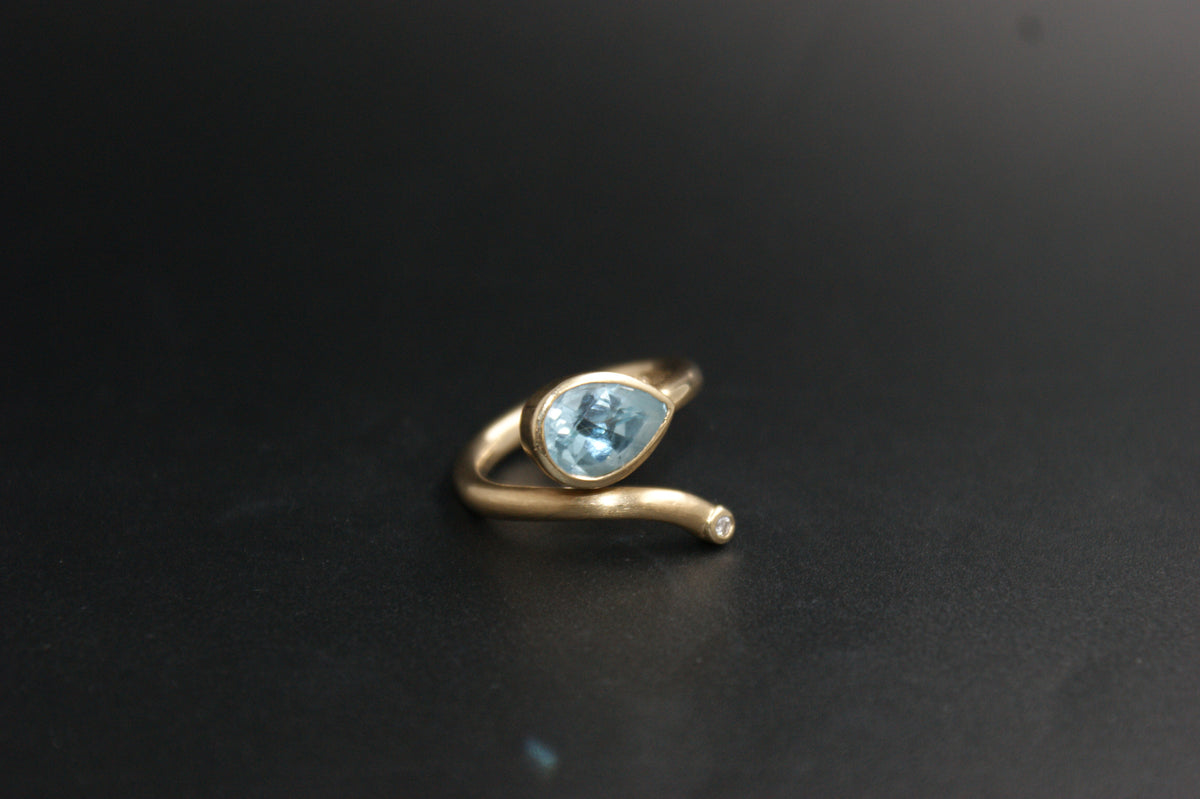 0186- 14ct Yellow Gold Blue Topaz and Diamond Bypass Ring