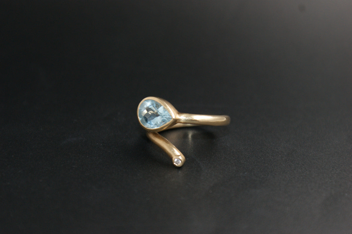 0186- 14ct Yellow Gold Blue Topaz and Diamond Bypass Ring
