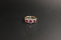 0212- 9ct Gold Three-Stone Ruby and Diamond Halo Ring