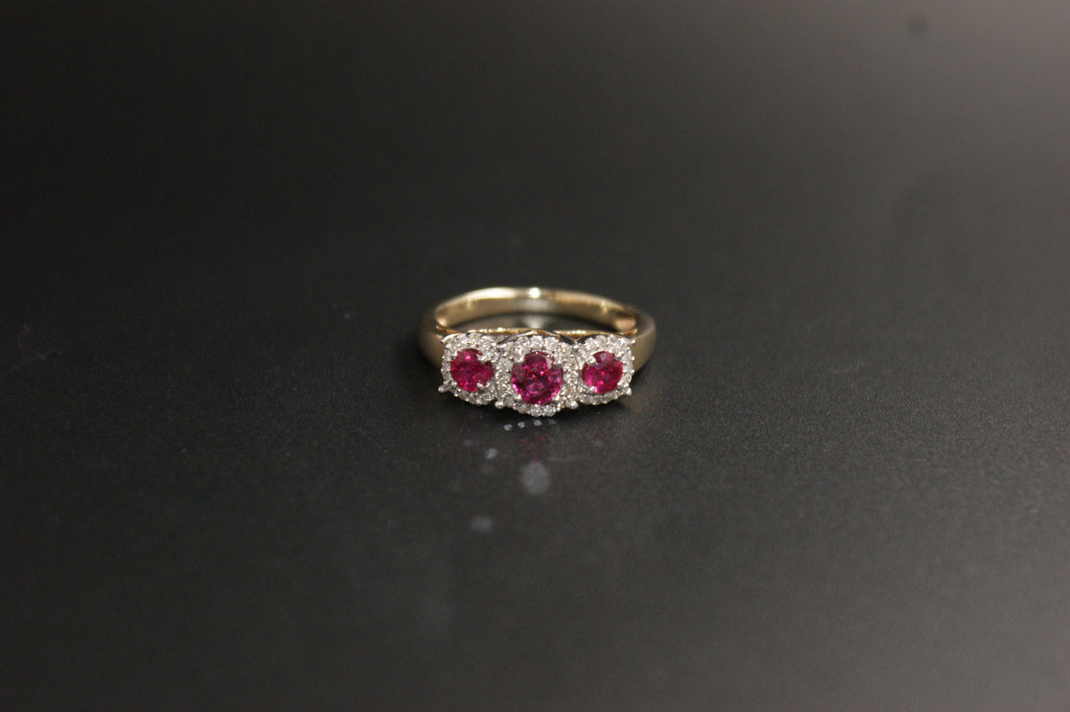0212- 9ct Gold Three-Stone Ruby and Diamond Halo Ring